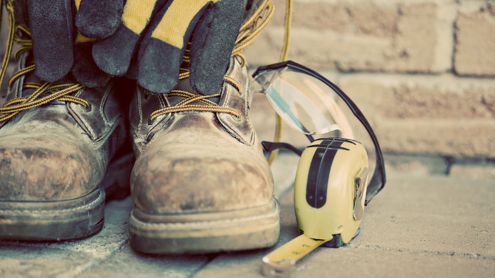 Hand using a mobile app with a laptop in the background.